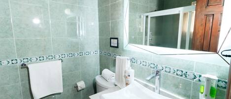 A bathroom with a white sink, toilet, and mirror.