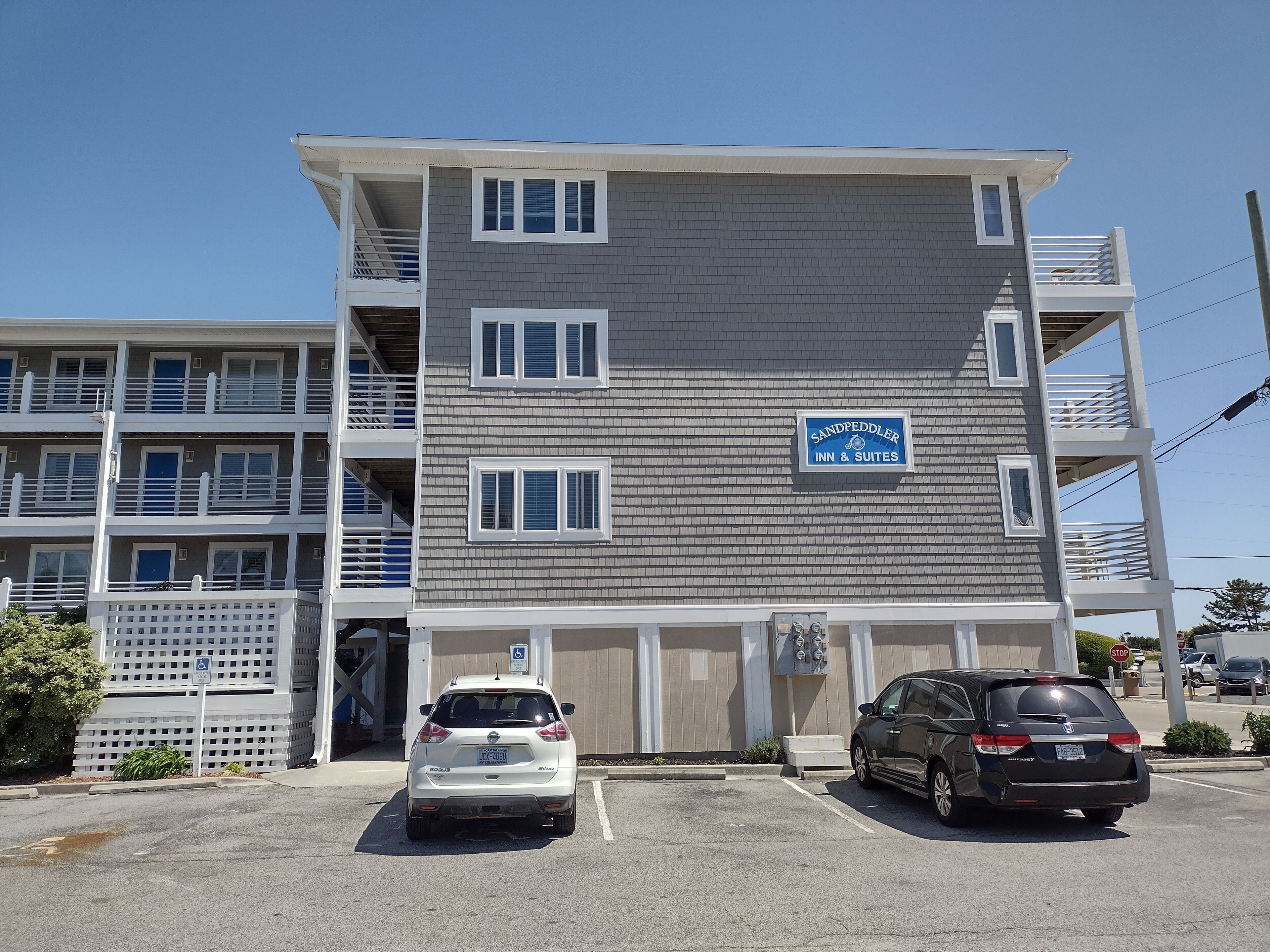 A multi-story hotel with a sign indicating it offers rooms and suites.