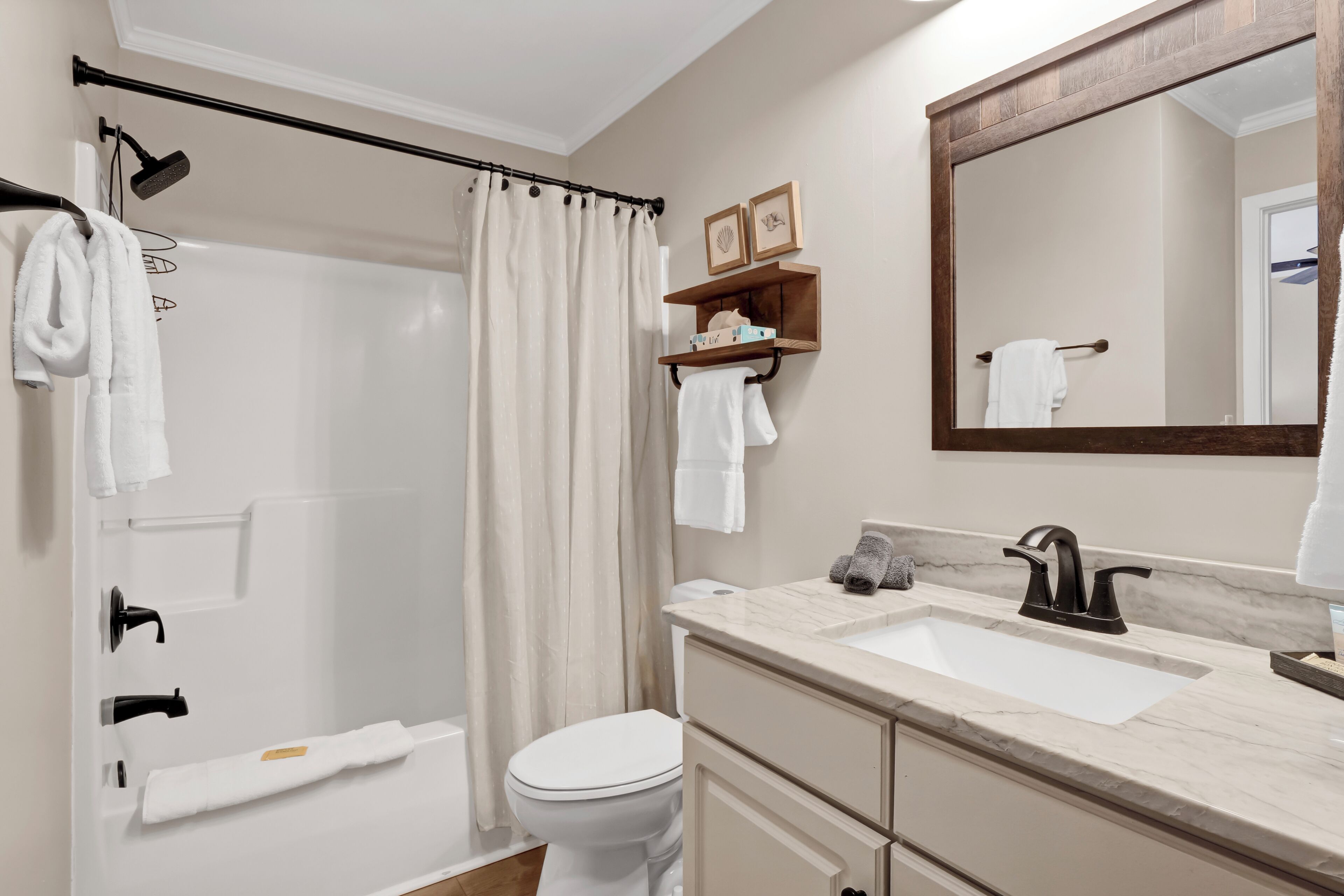 Une salle de bain moderne équipée d’une douche, de toilettes et d’un meuble-lavabo.
