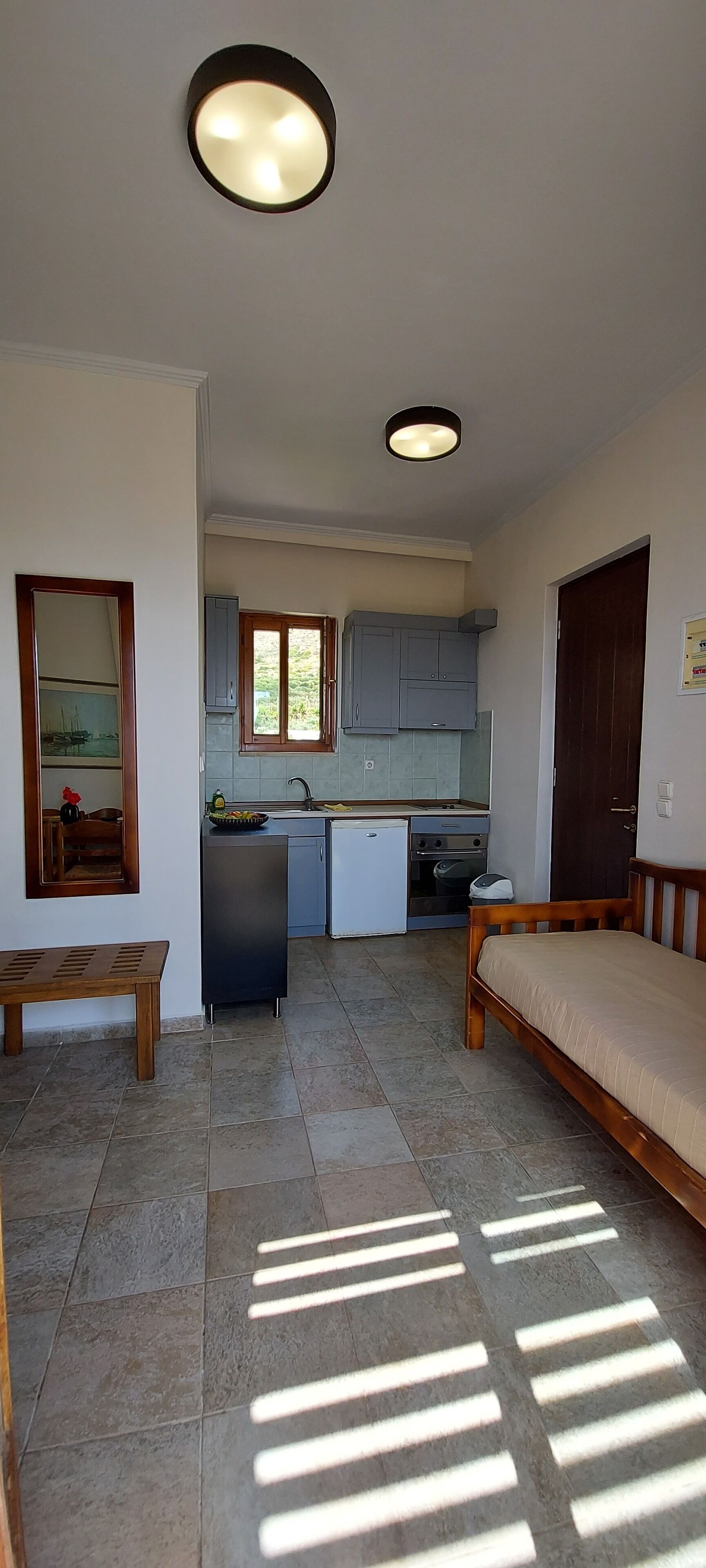 A compact living space with a kitchenette, a dining area, and a bed.