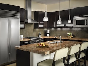 Enjoy cooking in this kitchen with sleek appliances, a granite countertop, and a central island with bar seating.