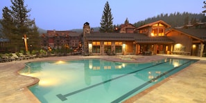 Relax by the resort pool, surrounded by lodge-style buildings and lush landscaping.