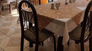 Comedor con una mesa dispuesta para cuatro personas, rodeada de sillas con asientos acolchados.