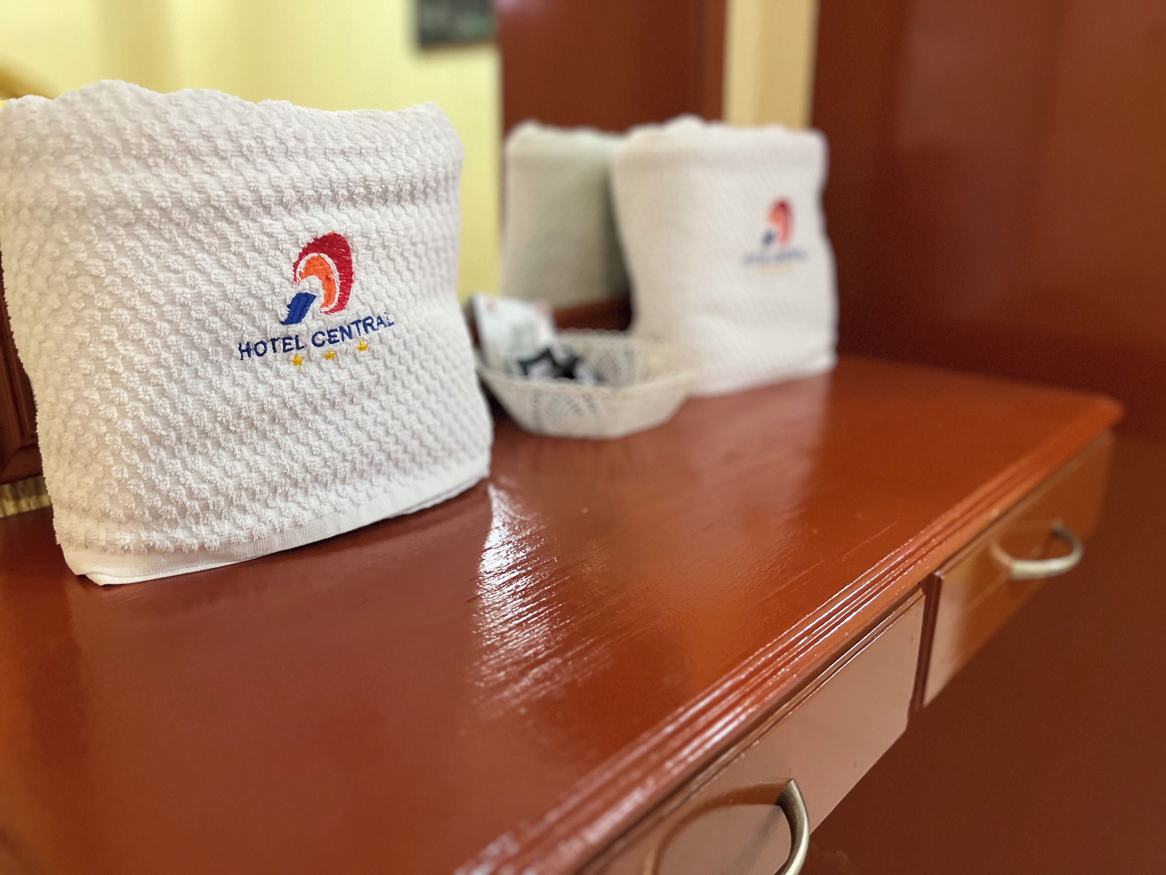A white textured towel with a logo and text indicating it is from Hotel Central.