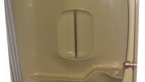 A toilet with a white seat cover and a visible toilet paper roll. - Ivanhoe Motel (Lloydminster)