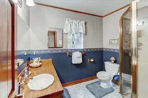 Bathroom features a classic design with a wooden vanity, white sink, and mirror.