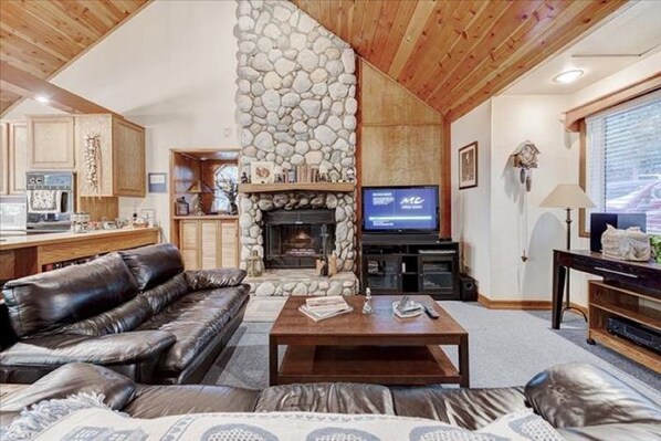 Relax by the fireplace in this inviting living room with a sofa and TV.