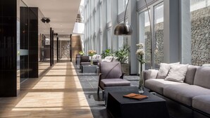 A modern lobby with a long corridor, seating area, and a staircase. - Dazzler by Wyndham Colonia (Colonia del Sacramento)