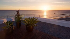 A rooftop terrace with potted plants and a view of the sunset over the ocean. - Dazzler by Wyndham Colonia (Colonia del Sacramento)