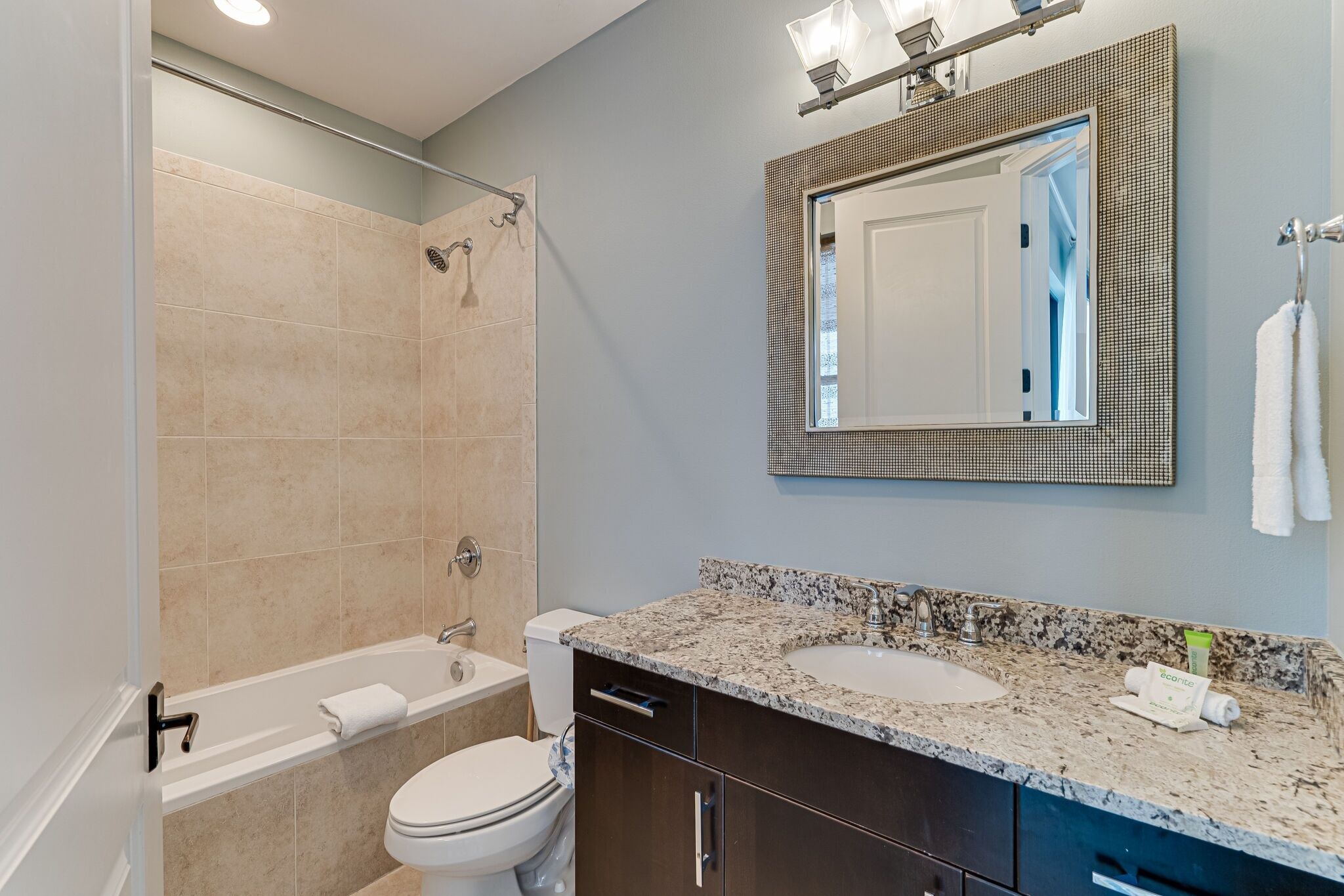 A modern bathroom with a bathtub, toilet, and sink.