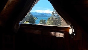 Dormitorio con vistas a un paisaje montañoso a través de un tragaluz.