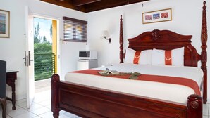 Une chambre à coucher avec un lit à baldaquin, une table de chevet, une lampe et une vue sur l’extérieur.