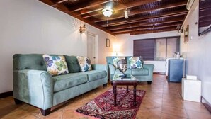 Un salon avec un canapé, une table basse et un tapis à motifs.