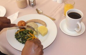 A plate with food and a cup of coffee on a table.
