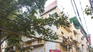 Un edificio de varios pisos con un letrero llamativo que dice 'Hotel Sunshine'.