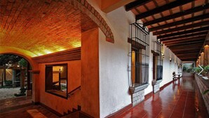 A corridor with a brick ceiling, white walls, and wooden beams. - Marina (Copan)