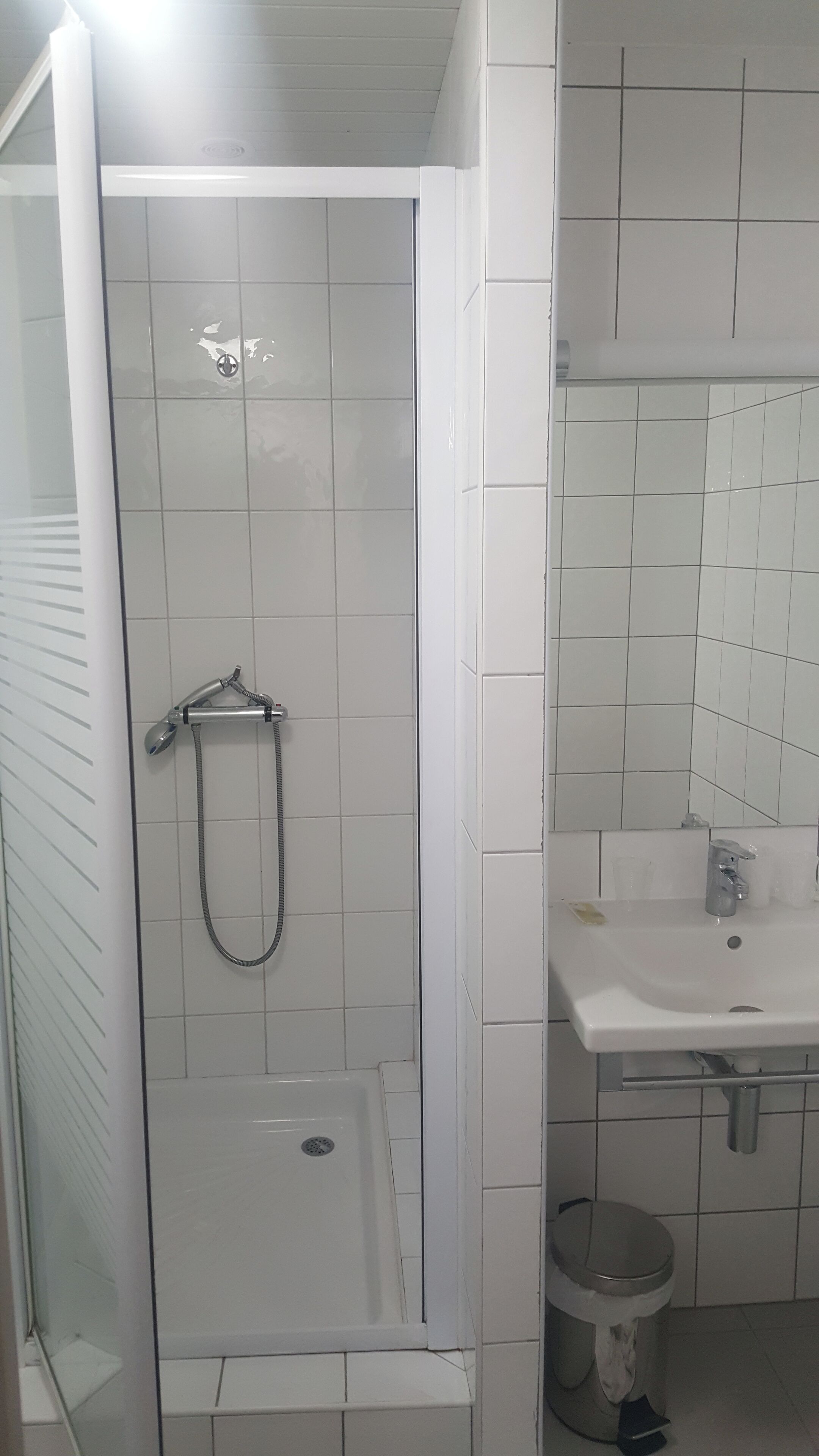A bathroom with a shower, sink, and toilet.