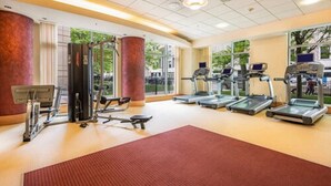 Un gimnasio con cintas de correr, elípticas y equipo de pesas.