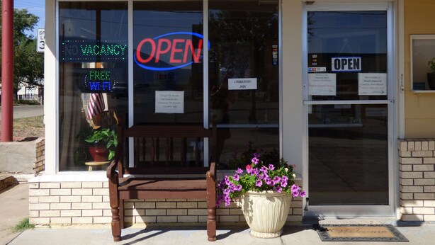 A motel with a 'VACANCY' sign, a 'FREE WIFI' sign, and a 'OPEN' sign on the window. - Carrizozo Inn (Carrizozo)
