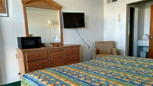 A hotel room with a bed, a dresser, a television, and a chair. - Carrizozo Inn (Carrizozo)