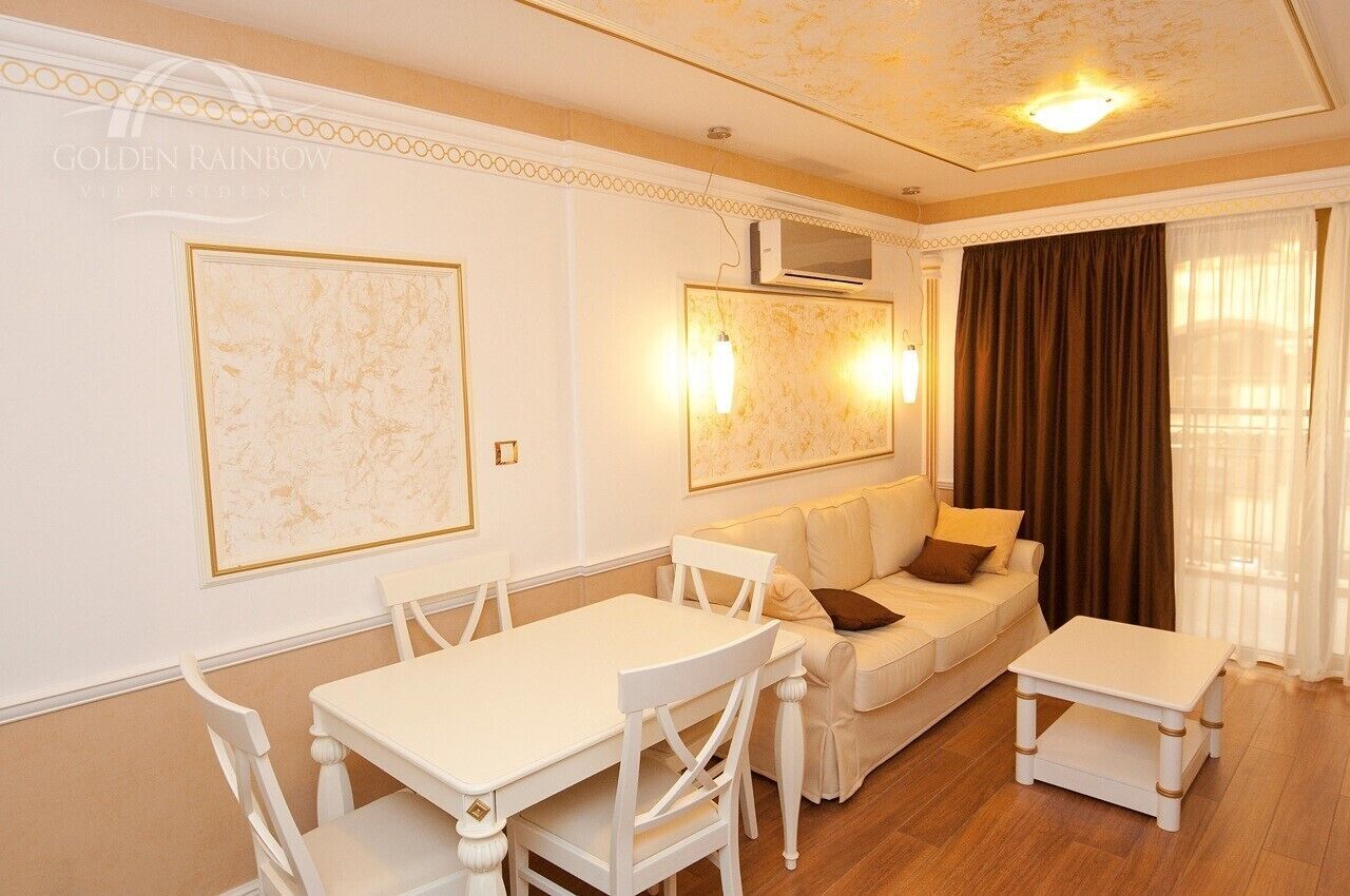 A well-lit living room with a dining area, featuring a sofa, a coffee table, and a dining table with chairs.