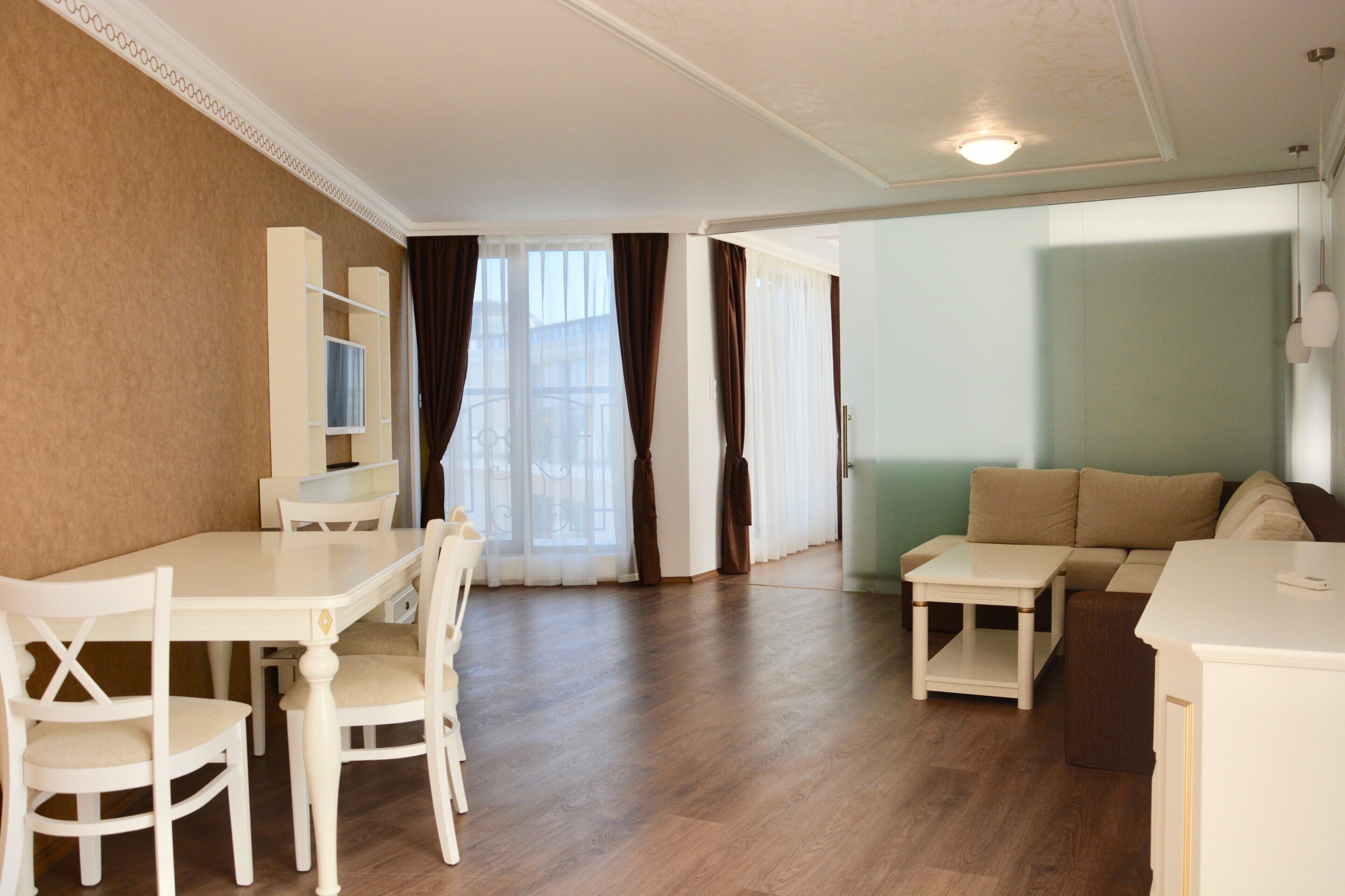 A living room with a dining area, a sofa, and a TV.