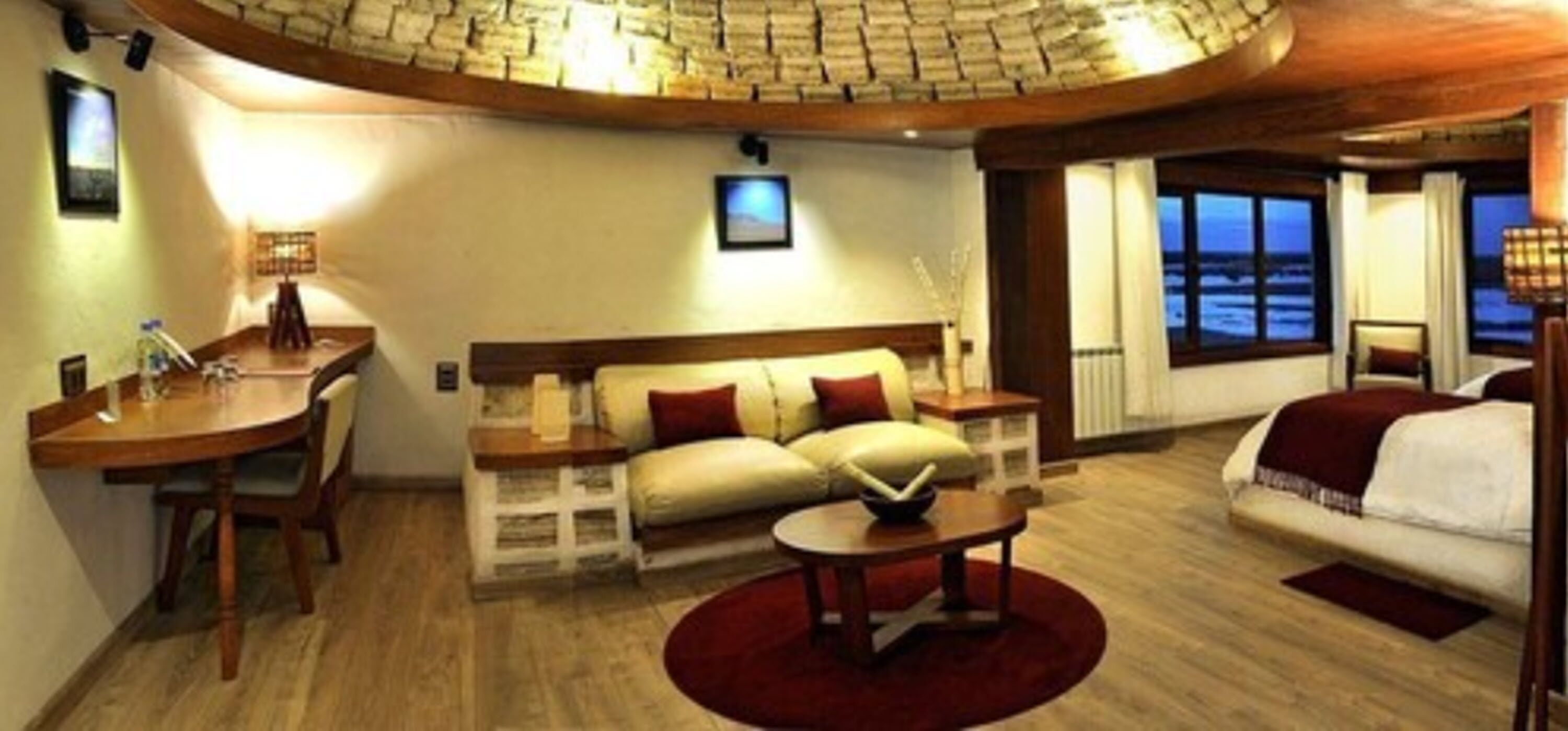 Et hyggeligt rum med buet loft, en sofa, et spisebord og havudsigt.