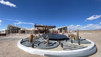 Welcome to Palacio de Sal, a hotel set amidst a serene desert landscape with a beautifully landscaped entrance.