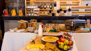 A buffet setup with various food items, beverages, and condiments.