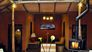 A cozy interior with wooden furniture, a fireplace, and a glass ceiling.