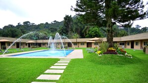 A hotel courtyard with a swimming pool, stepping stones, and a large tree. - Layfer Express Cordoba Veracruz Mexico (Córdoba)