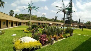 A hotel courtyard with a swimming pool, palm trees, and well-maintained lawns. - Layfer Express Cordoba Veracruz Mexico (Córdoba)
