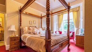 Una cama con dosel de madera y un suelo cubierto de alfombra roja.