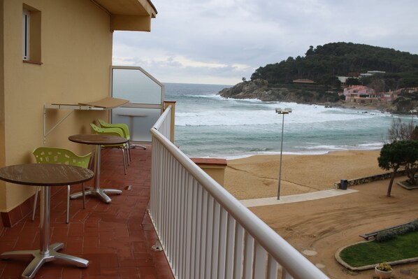 A balcony with outdoor seating and a view of the beach and ocean. - Hostal LA Fosca (Palamós)
