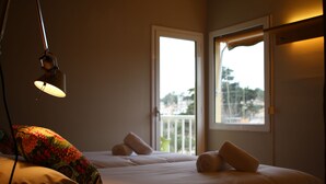 A hotel room with a bed, a lamp, and two windows. - Hostal LA Fosca (Palamós)