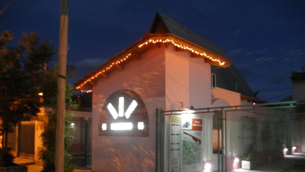 Um edifício com uma entrada em arco característica e uma placa em cima.