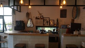 Una zona de bar con taburetes, una barra y diversos electrodomésticos de cocina.
