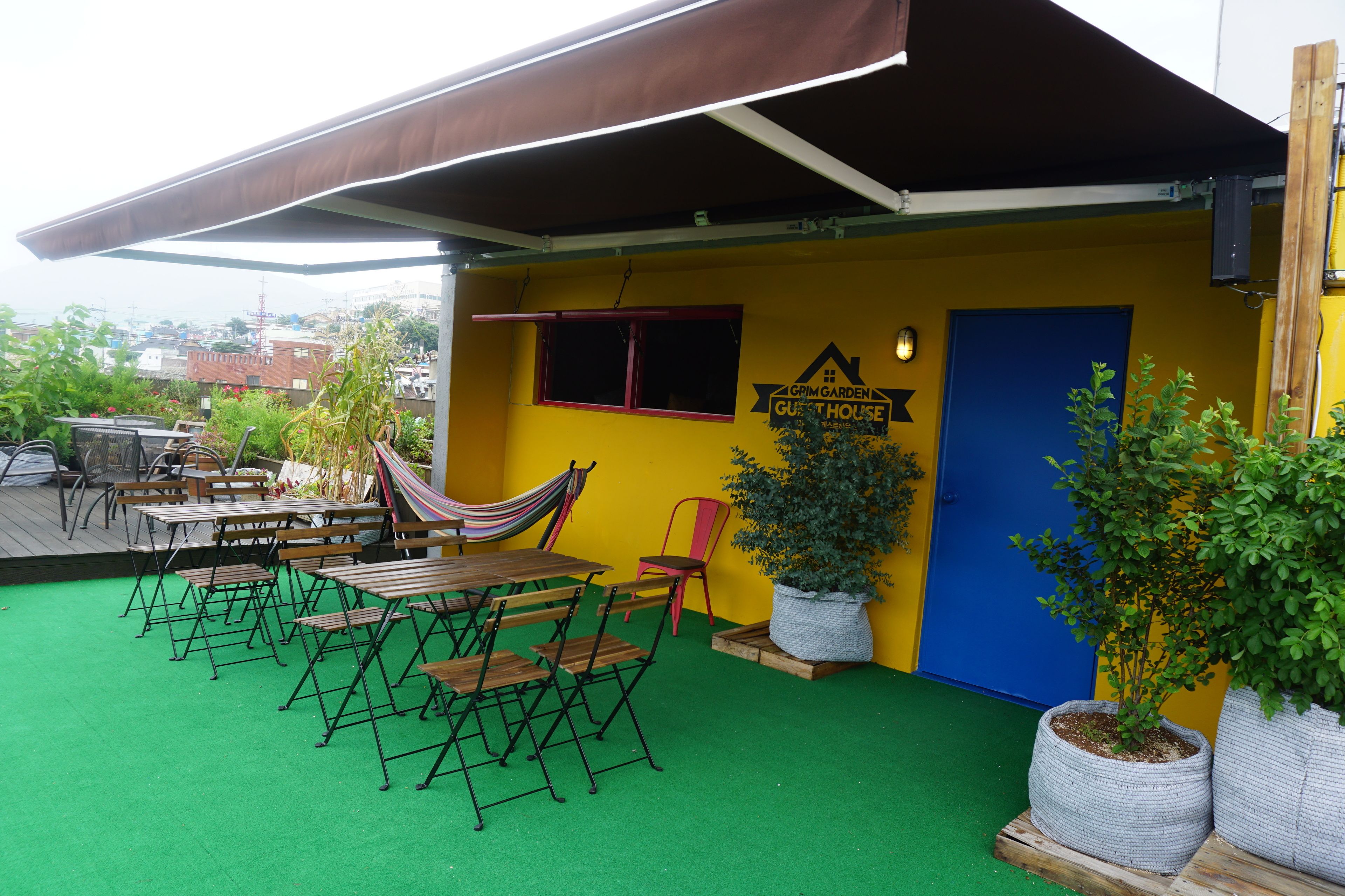 A patio area with outdoor furniture, a hammock, and potted plants.