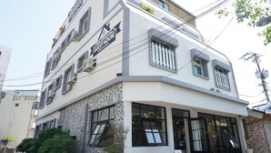 Un edificio de varios pisos con diseño moderno, con ventanas amplias y un cartel que dice 