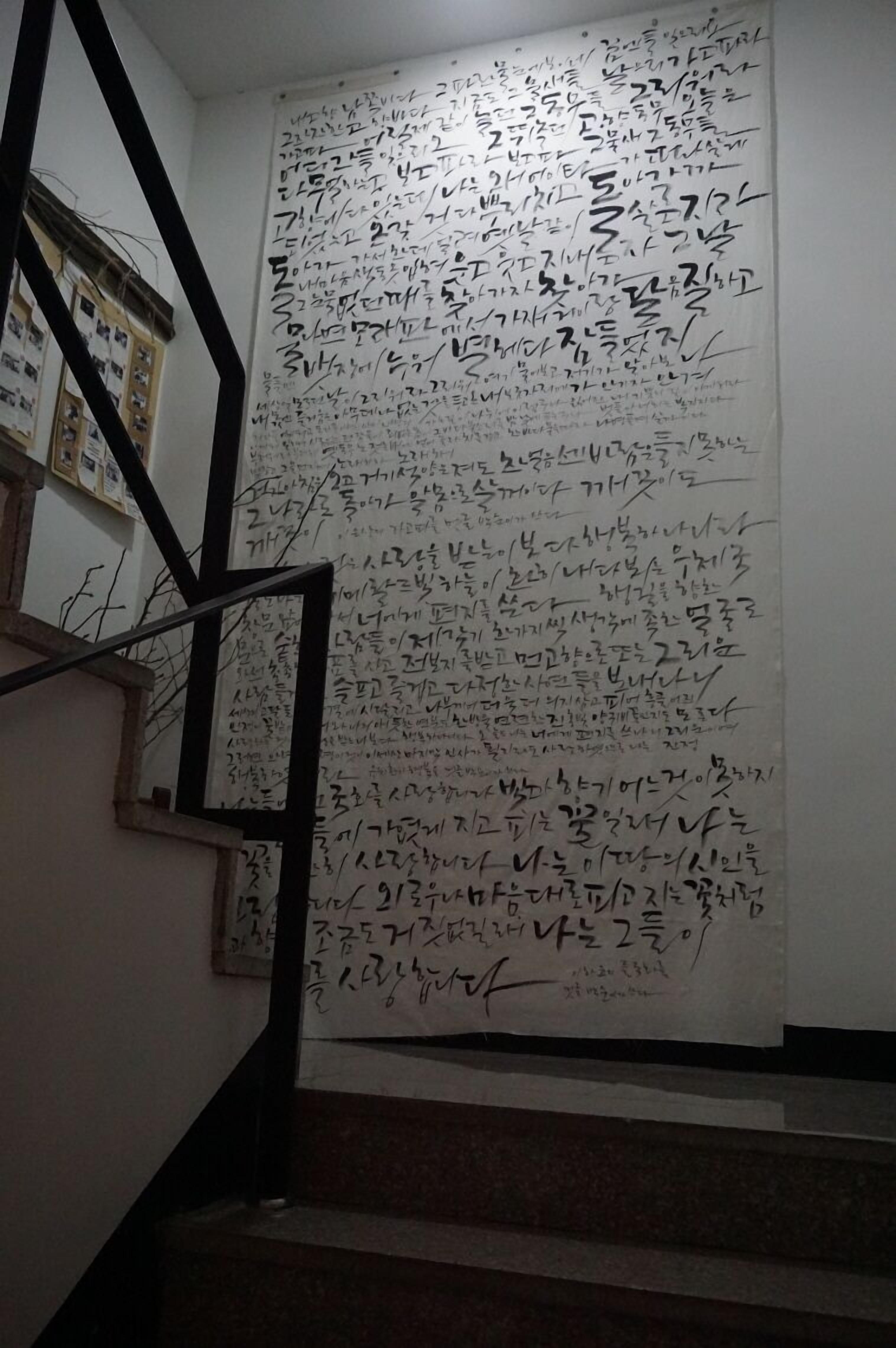 A staircase with a large white wall covered in handwritten notes.