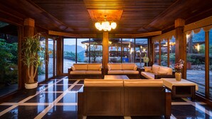 A spacious lobby with a wooden ceiling, large windows, and a central seating area with sofas and a table. - WULAI SungLyu spring resort (New Taipei City)