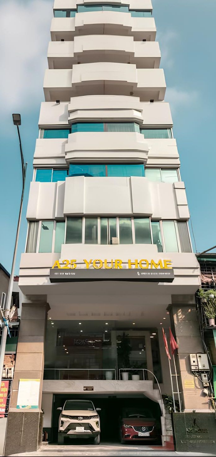 Un edifici modern amb un rètol que diu "A25 YOUR HOME" i un garatge amb dos cotxes a dins.