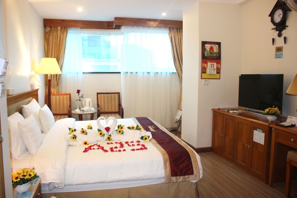 Une chambre d’hôtel avec un lit, une télévision, un bureau et une chaise.