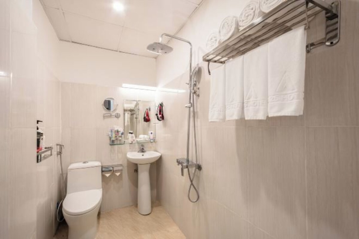 A modern bathroom with a toilet, sink, and shower.