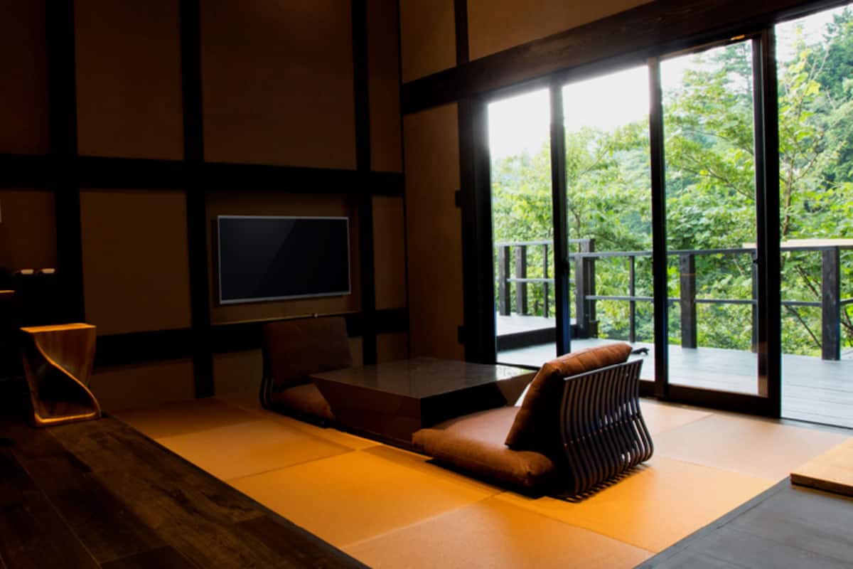 Ein modernes Wohnzimmer mit einem großen Flachbildfernseher, einer Couch und einem Couchtisch aus Holz.