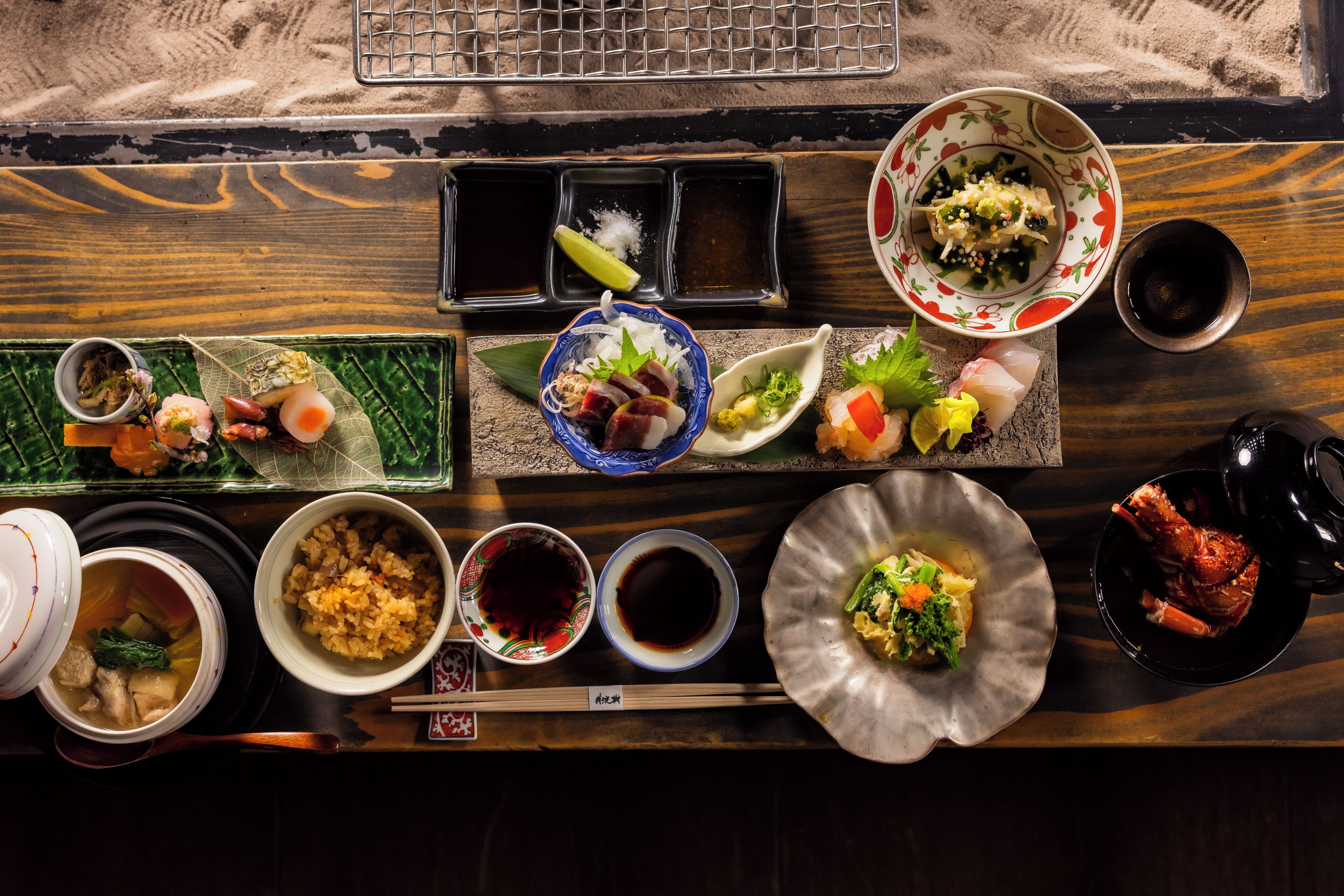 A variety of Japanese dishes arranged on a wooden table.