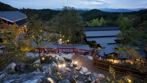 Un edificio de estilo japonés tradicional con un puente rojo y un sendero de piedra.