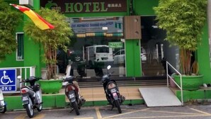 A green building with a sign reading "HOTEL" and a wheelchair accessibility sign. There are motorcycles parked in front. - Green Hotel (Sungai Besar)