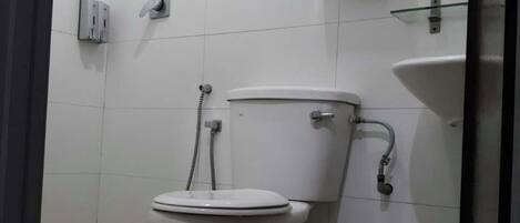 Un baño con inodoro, ducha y lavamanos.