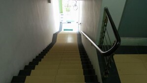A staircase with alternating black and yellow steps leading to a door at the top. - Green Hotel (Sungai Besar)